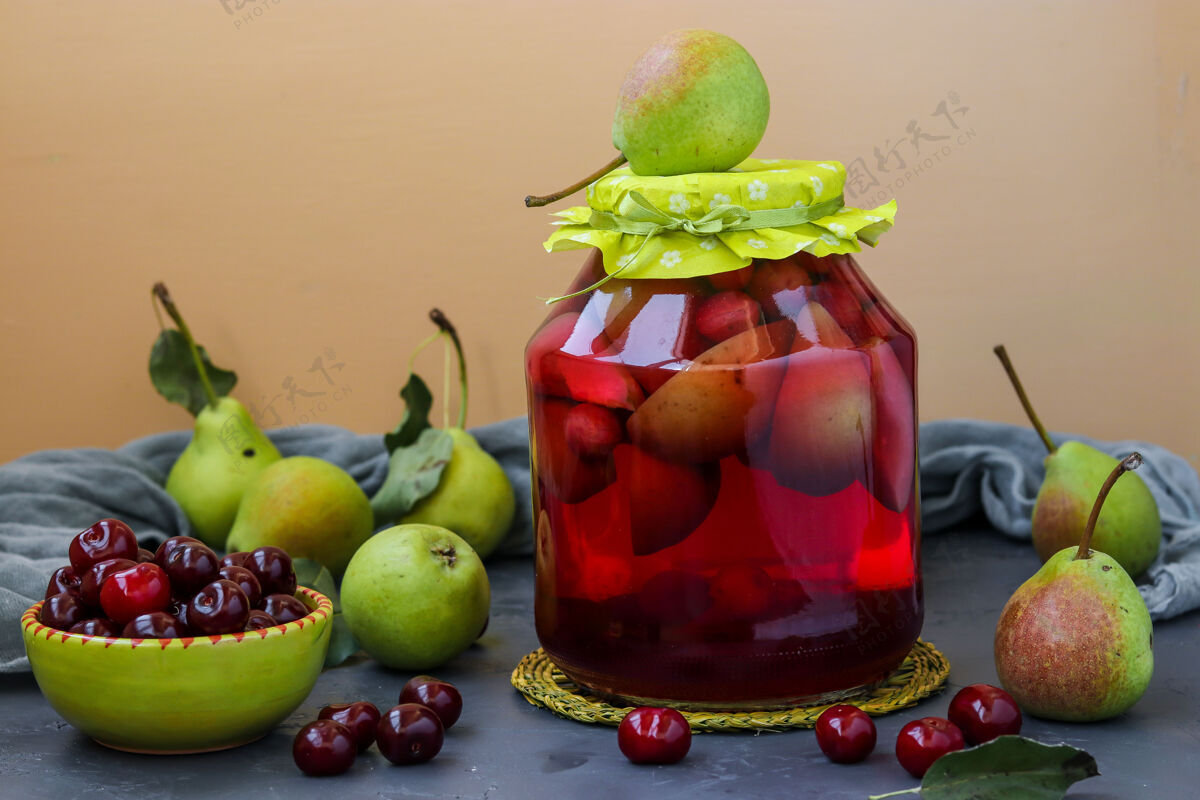 礼物把梨和樱桃放在罐子里放在桌子上 为冬天收割 水平方向 特写水平水果位置