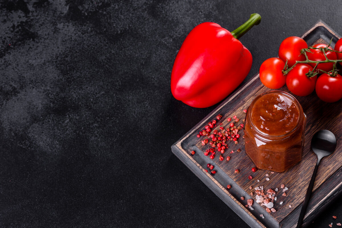 美味格鲁吉亚菜的辛辣调味料阿吉卡在一个碗里 用红辣椒和大蒜放在混凝土桌上特写镜头红色酱阿拉伯