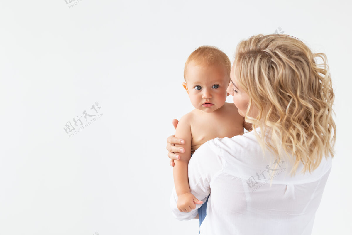 父母童年 母亲和家庭概念-肖像快乐的母亲抱着她的孩子在白色的表面母亲妈妈健康