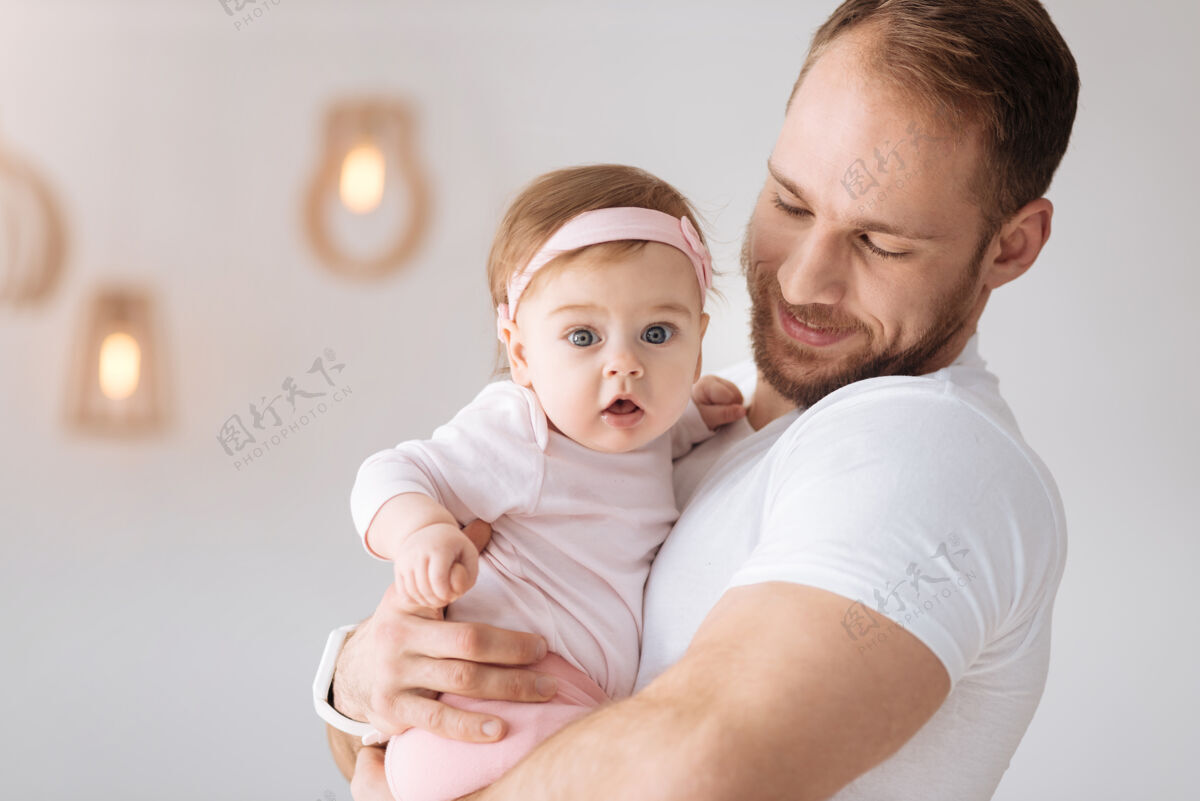 父亲参与每一个时刻快乐快乐的胡须父亲站在家里 拥抱着他的小女儿 同时表达温柔的情感和积极的态度父亲服务器父母