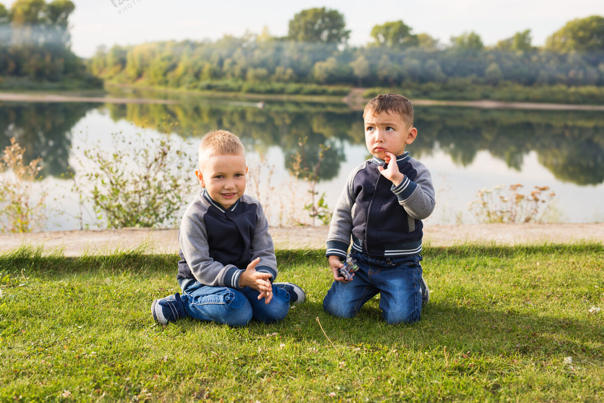 水儿童与自然概念——两兄弟坐在草地上的自然空间男孩家庭爱