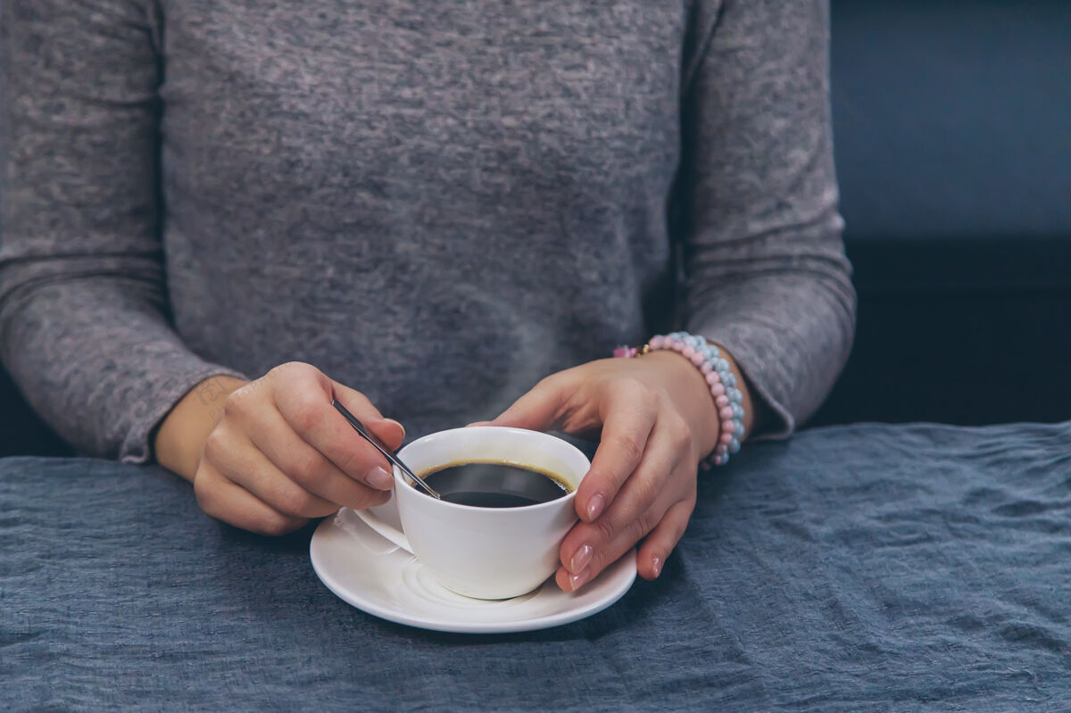 女士坐在桌边喝咖啡的女人饮料温暖科技
