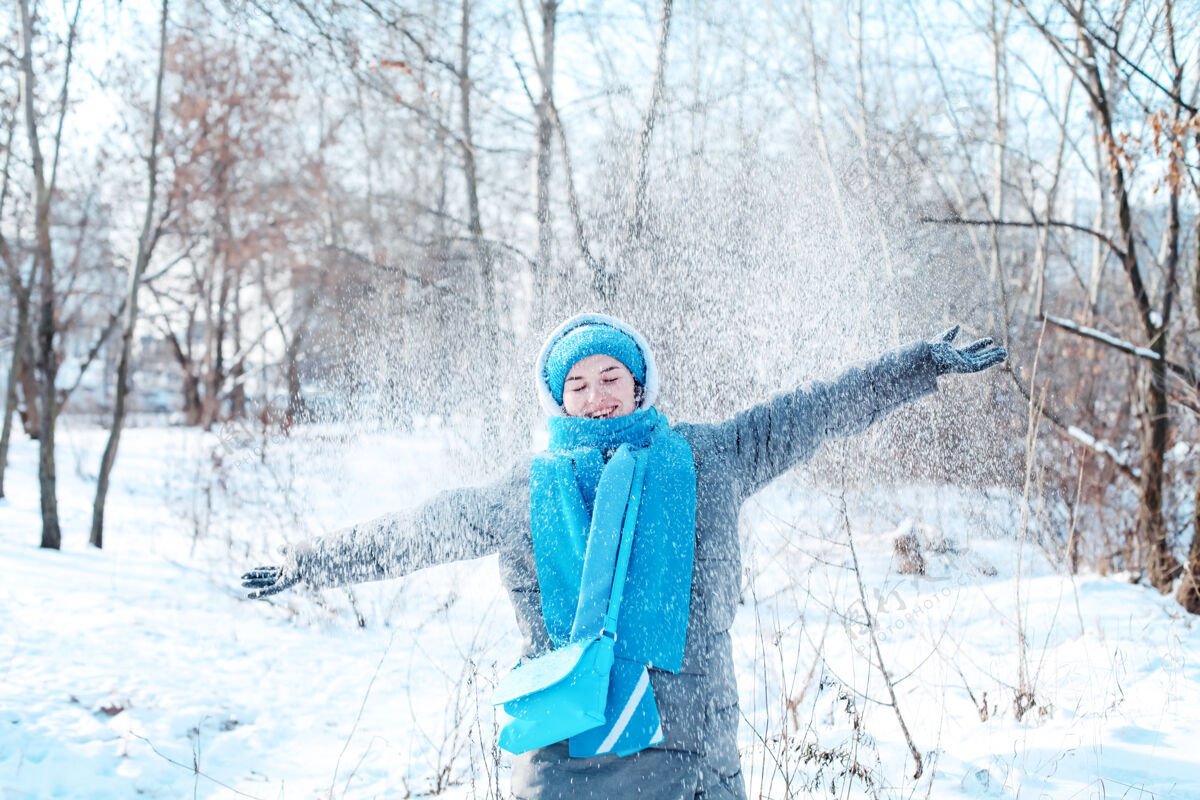 雪美丽的年轻女子笑容可掬 在雪季快乐旅行美丽吹户外