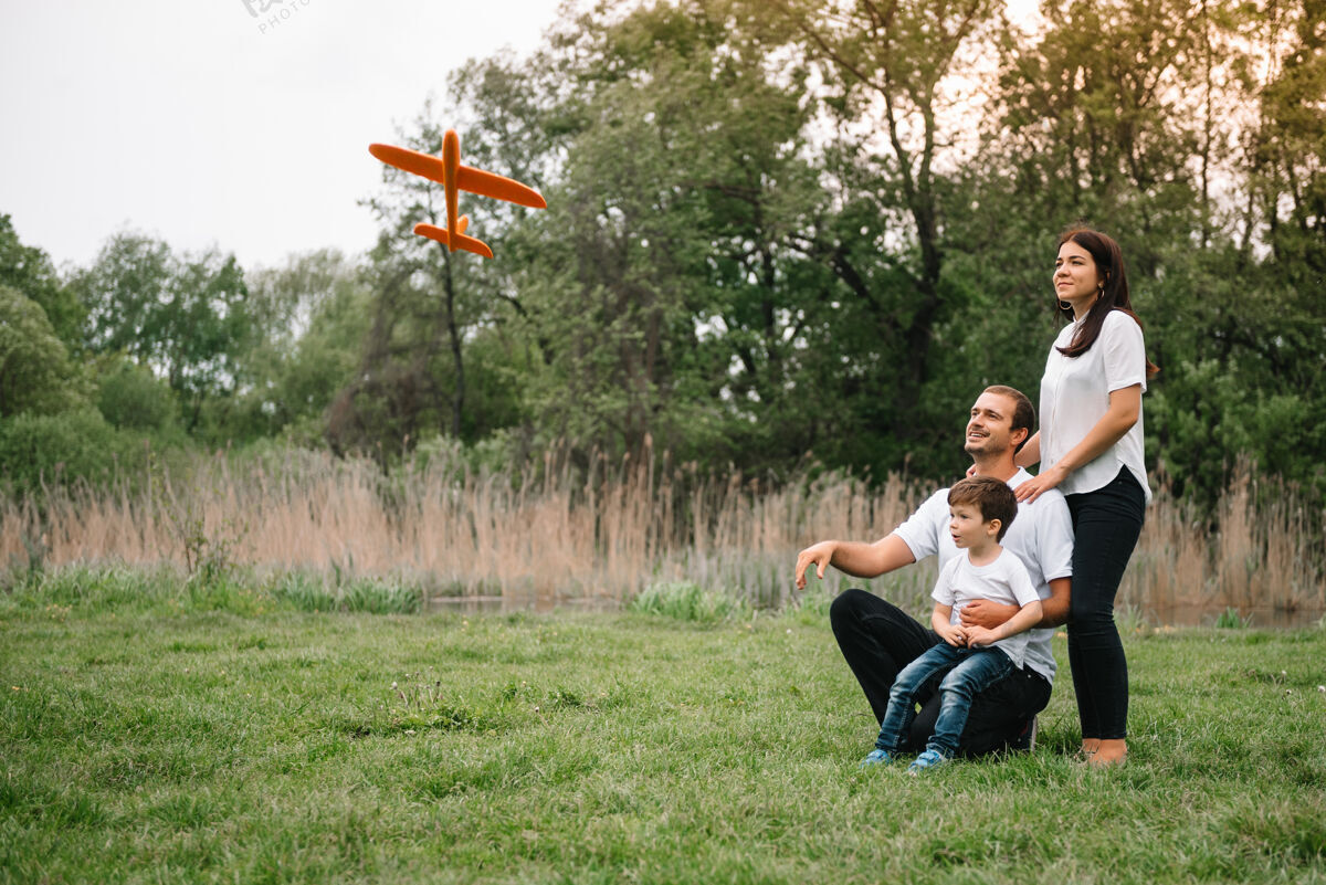 快乐爸爸 妈妈和儿子在公园里玩玩具飞机公园友好型家庭孩子假期乐趣