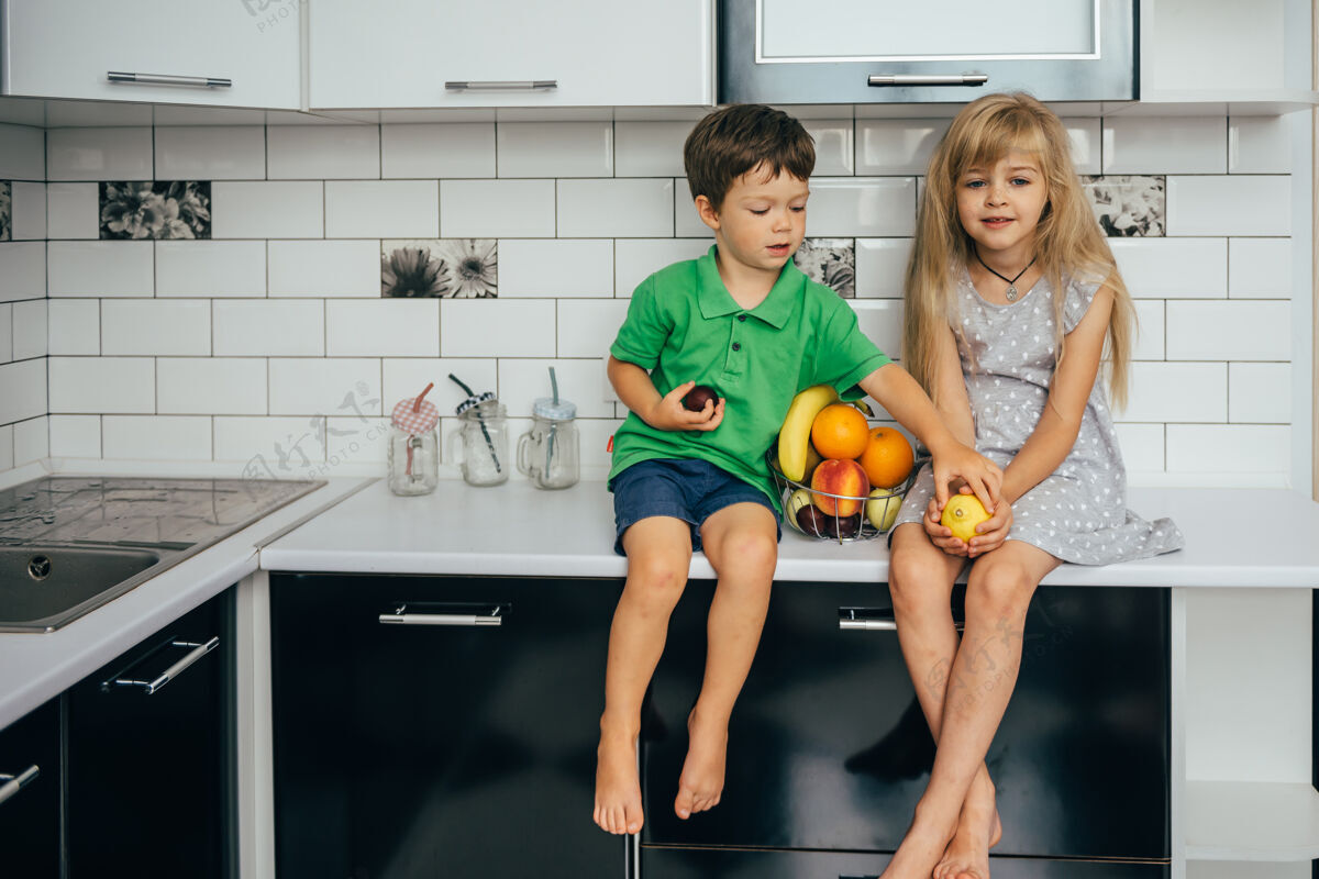 桌子健康的概念吃有趣孩子们在厨房里吃水果女性生活方式家庭