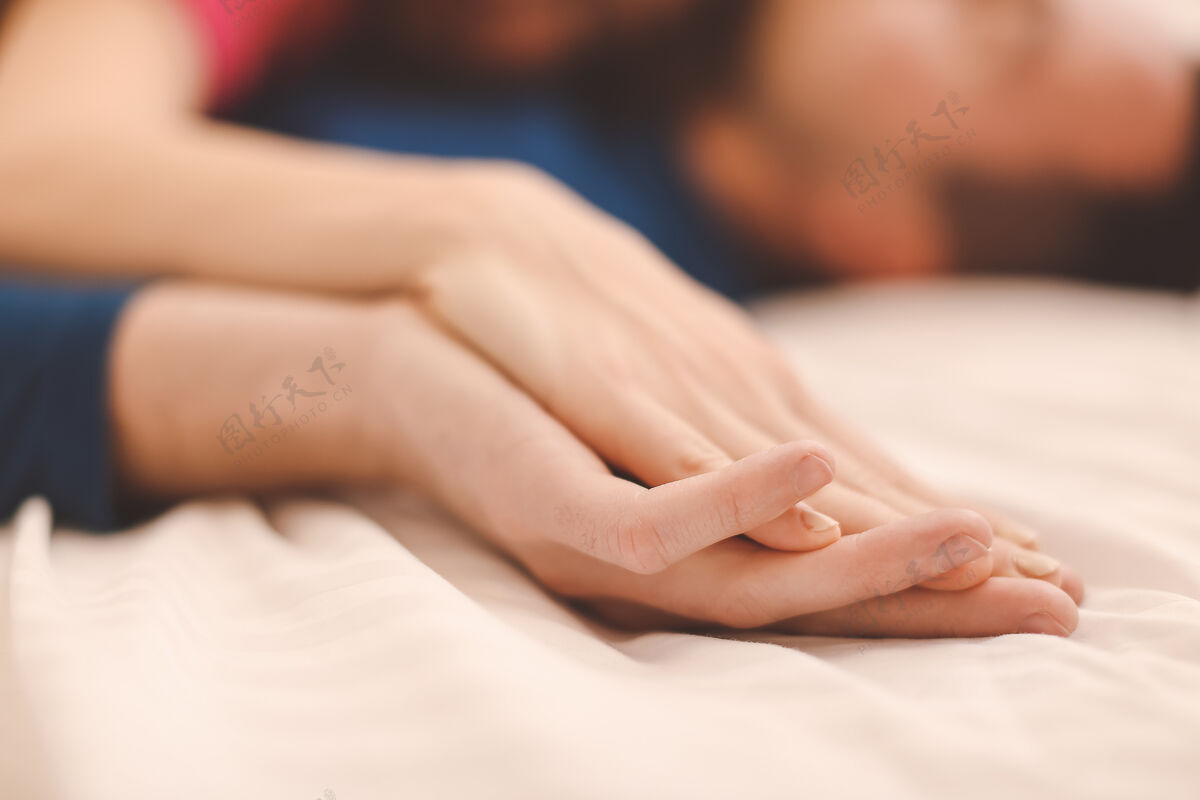 关系睡在床上的年轻夫妇的手生活方式夫妻休闲