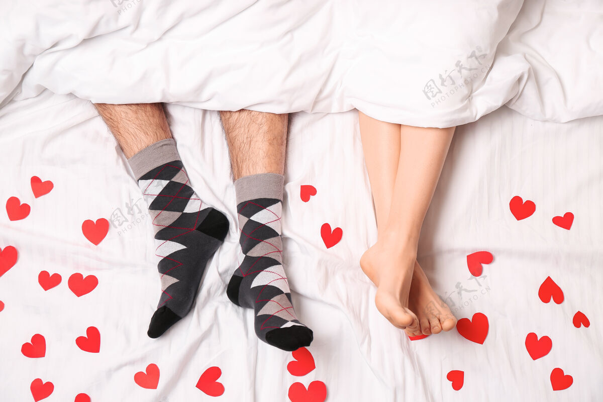 债券躺在床上的红心青年夫妇 顶视图平和床男人