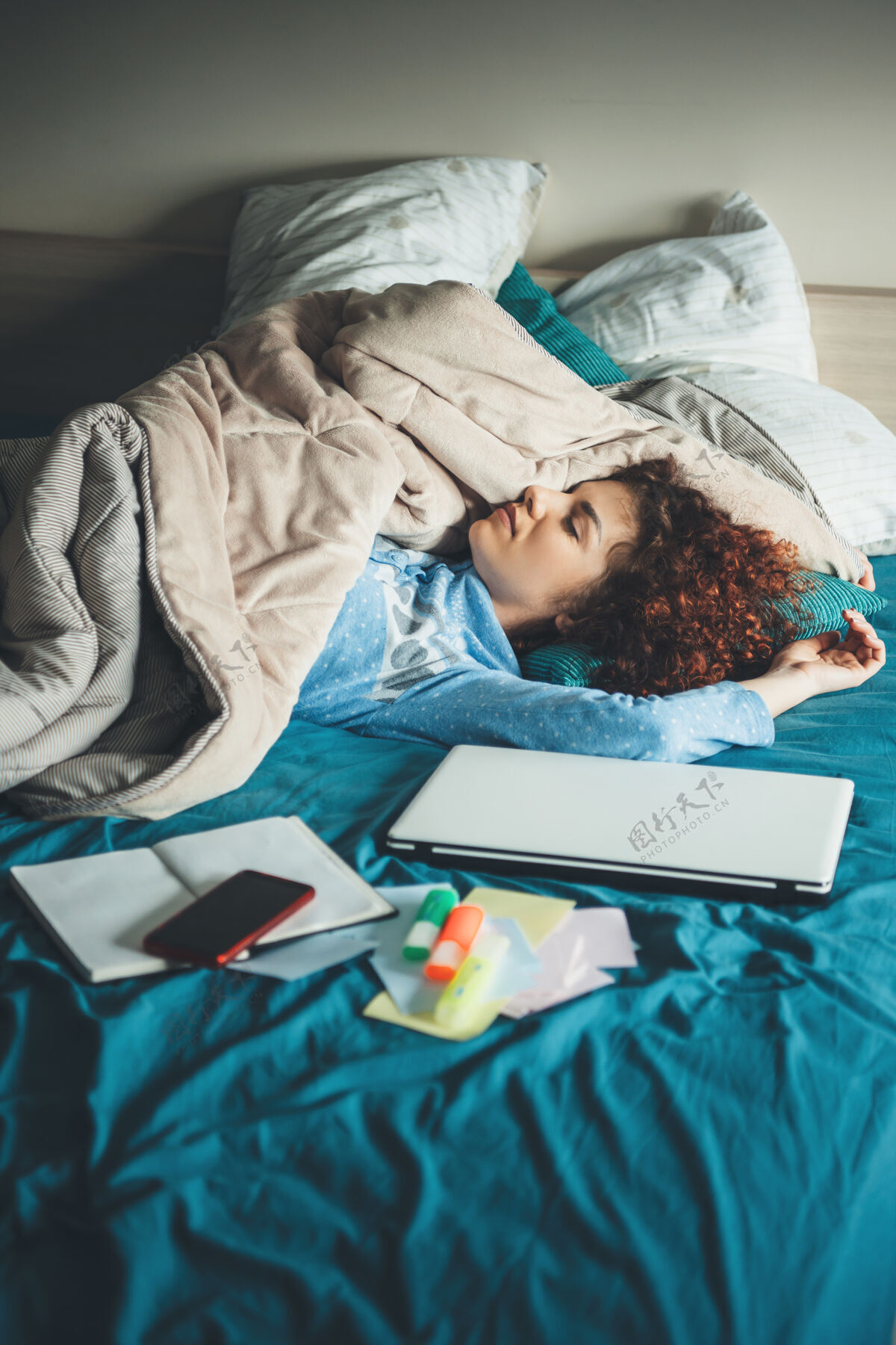 书房熟睡的高加索妇女在床上用笔记本电脑做作业后正在休息 笔记本电脑上盖着被单 穿着睡衣疲倦职业文书工作
