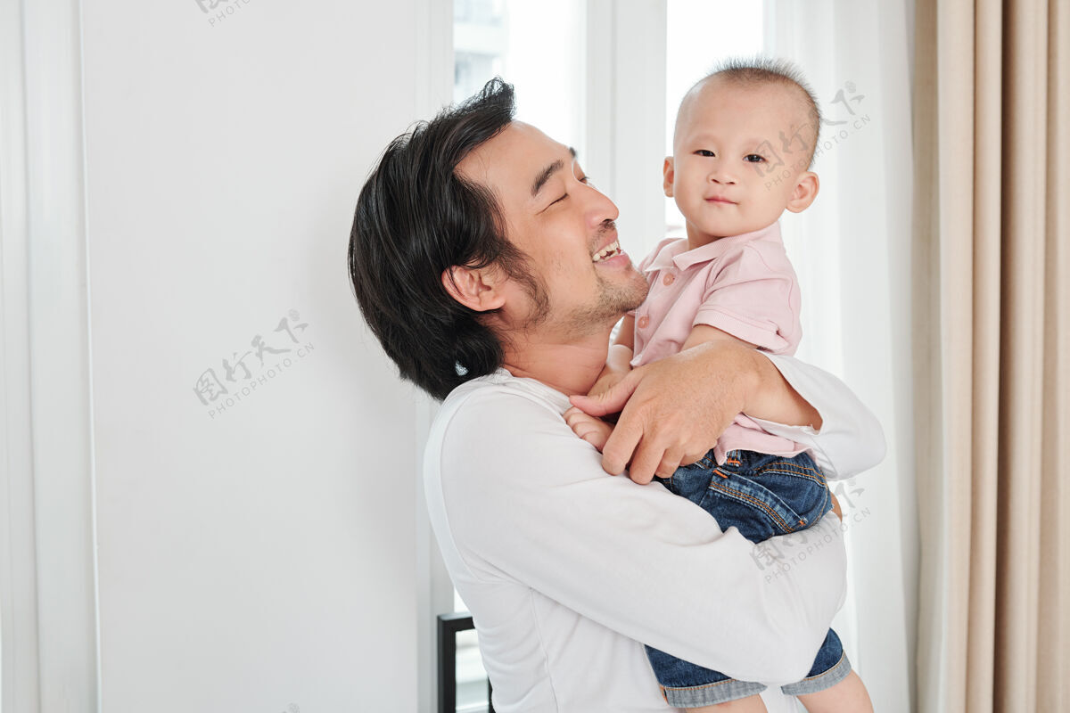 亚洲人快乐的越南男人喜欢和他的孩子在一起儿子 他抱着他 用爱和温柔看着他拥抱关怀团聚