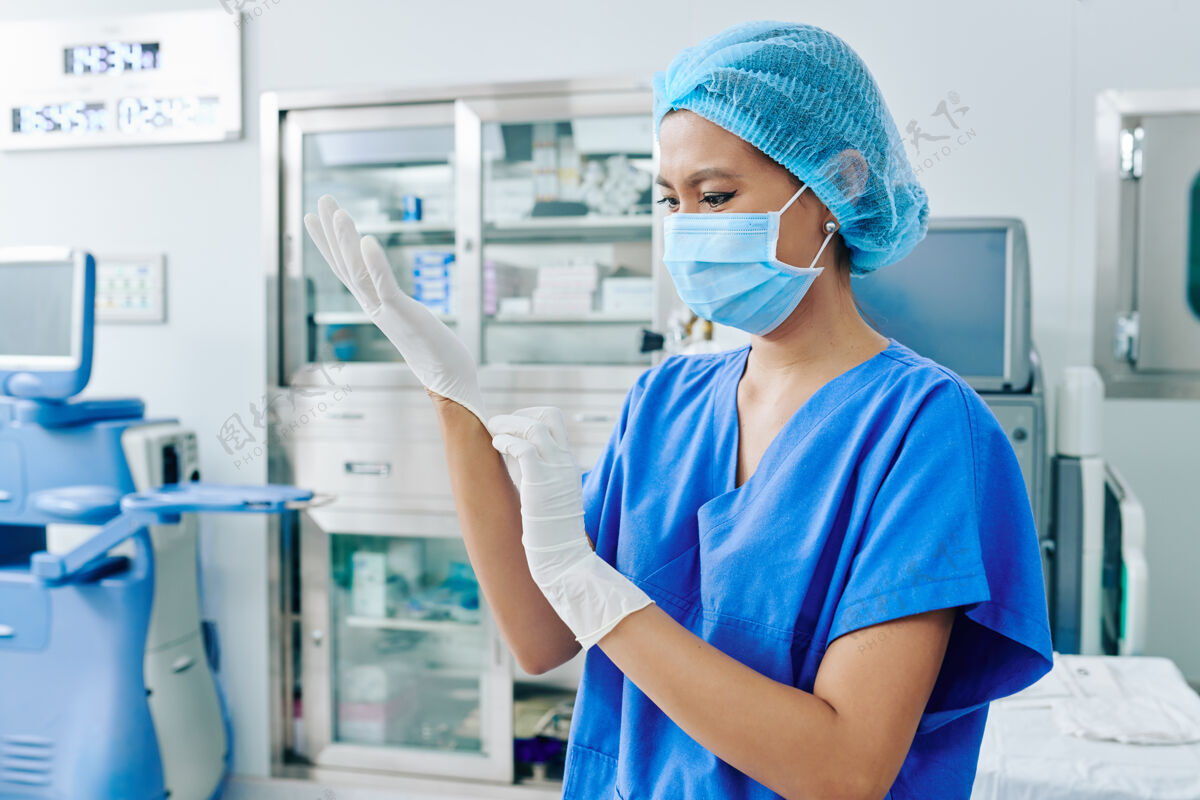 诊所戴着医用口罩的越南女外科医生戴上橡胶手套准备手术医疗诊所激光眼科学