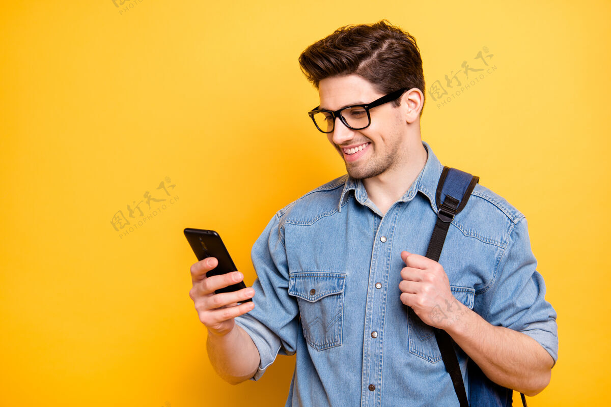 考试照片中 一个开朗帅气的帅哥穿着牛仔裤 在电话里闲逛 带着背包 牙牙学语地笑着留茬学校教育