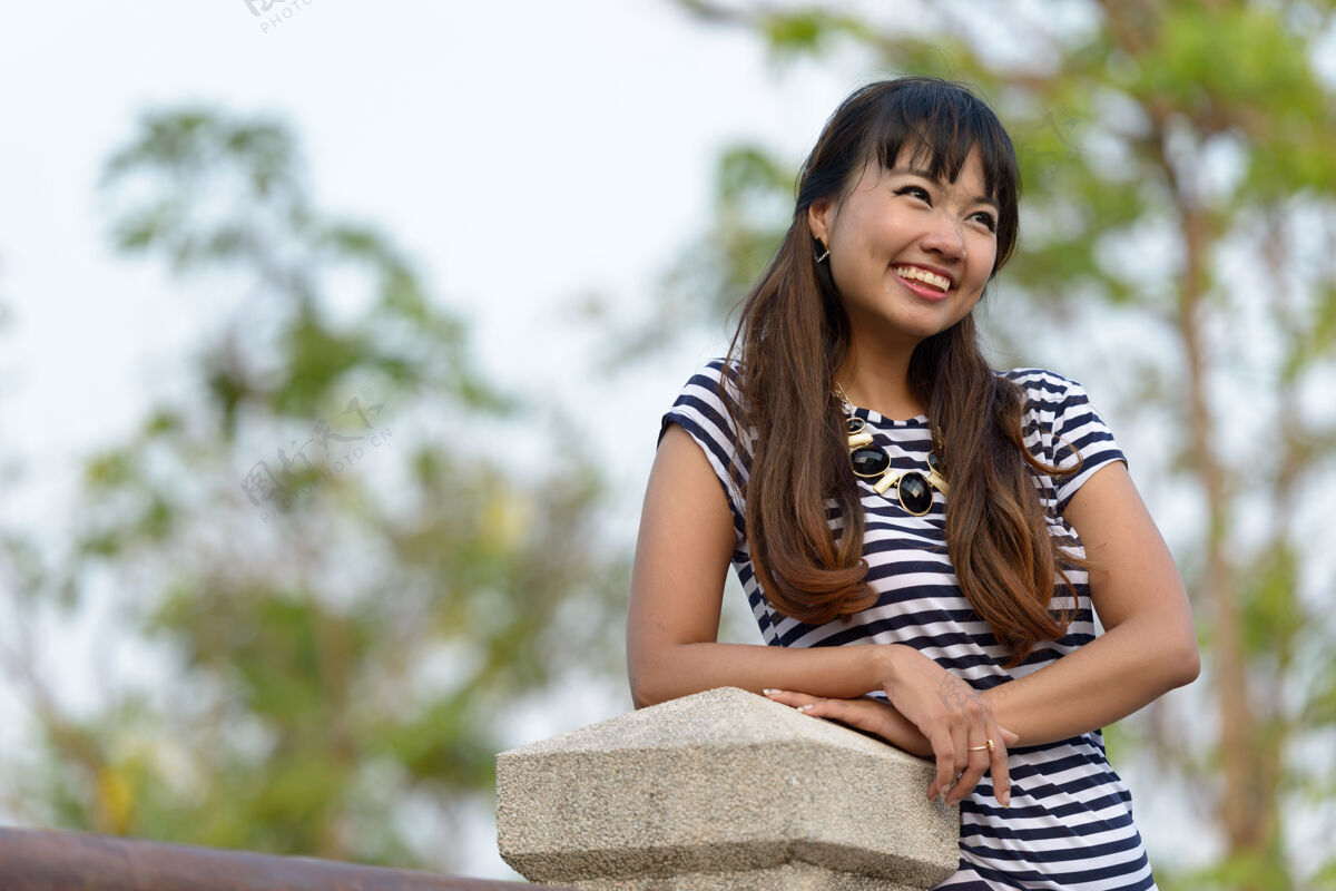 头发年轻美丽的亚洲女子在公园户外放松的写真休闲发型沉思