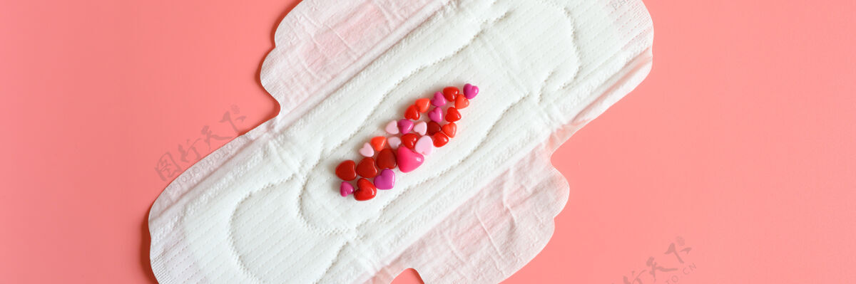垫女性月经时用的卫生巾或餐巾纸为正常分泌的大量分泌物 用红色珠子做成心形的仿血特写自然餐巾