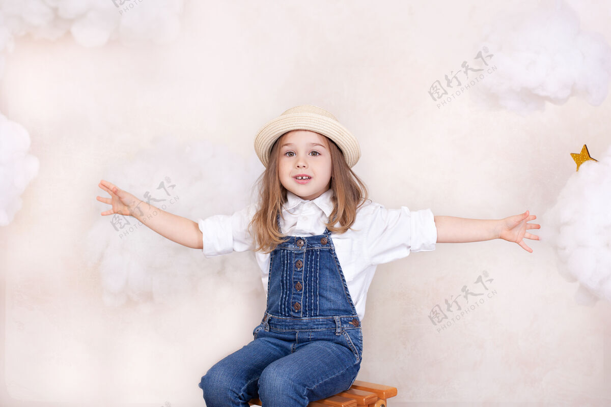 肖像穿着稻草的可爱小女孩的画像帽子微笑孩子带着云和星星在天空中飞翔小快乐女孩