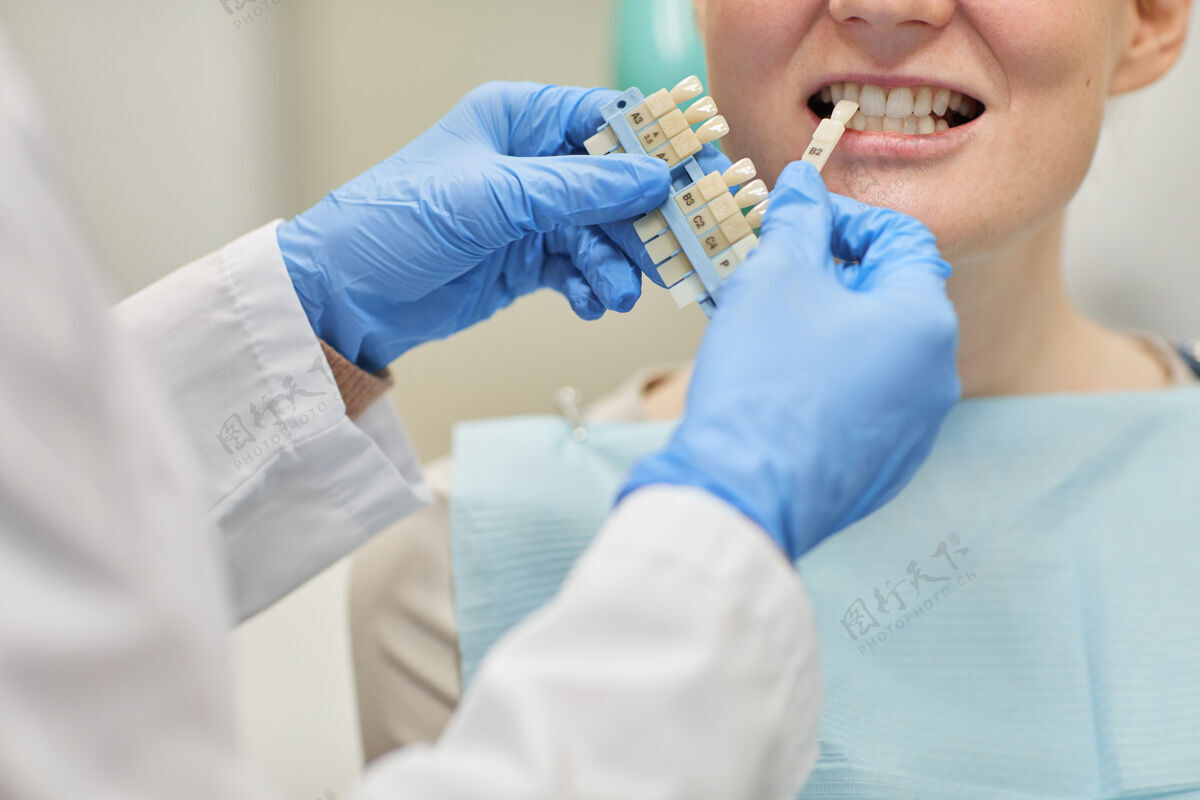 职业戴着防护手套的牙医在诊所为病人选择牙科植入物的特写镜头医生室内疾病