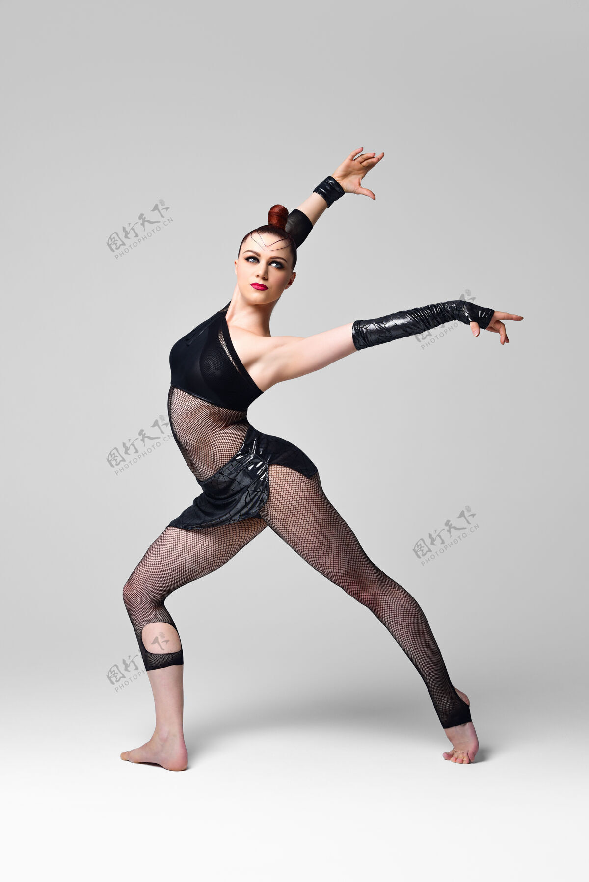 女性爵士乐现代舞者在一个富有表现力的舞蹈摆姿势女人穿着黑色表演服 妆容亮丽 发型流畅的舞者运动服装灵活