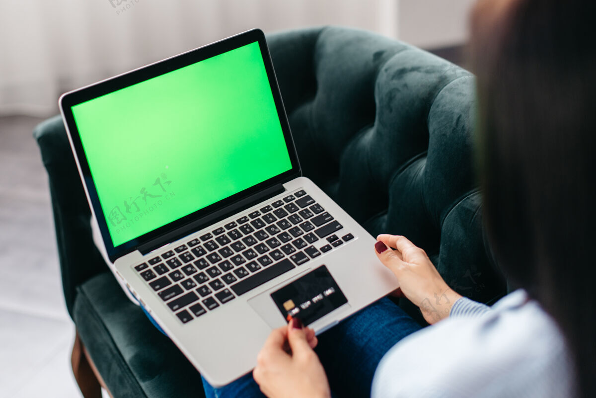 年轻人用信用卡在线购物的女性的贴身之手支付笔记本电脑借记
