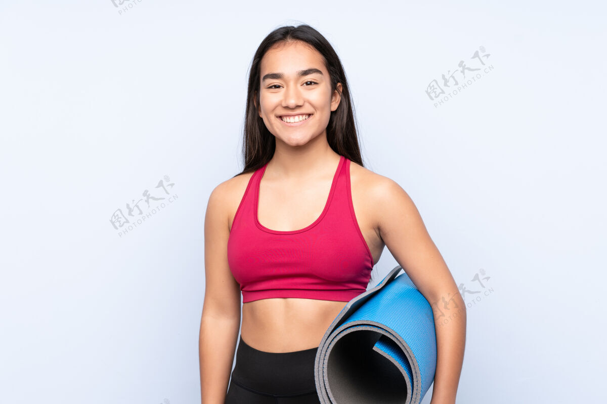 女人一个年轻的印度女运动员 穿着蓝色的垫子 面带微笑运动员年轻人健身房