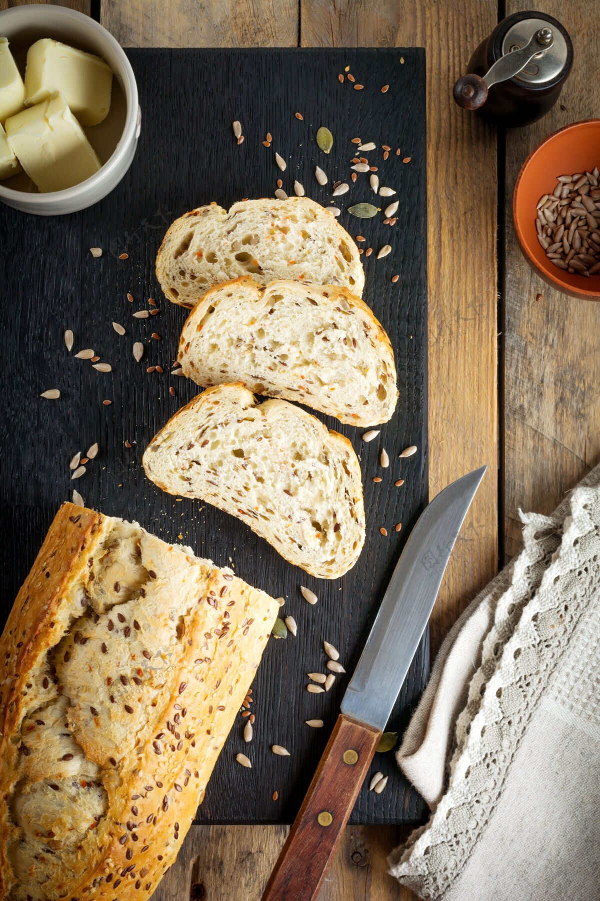 麸皮健康的面包与麸皮 葵花籽 南瓜 亚麻和芝麻在一个古老的木制表面晚餐种子健康