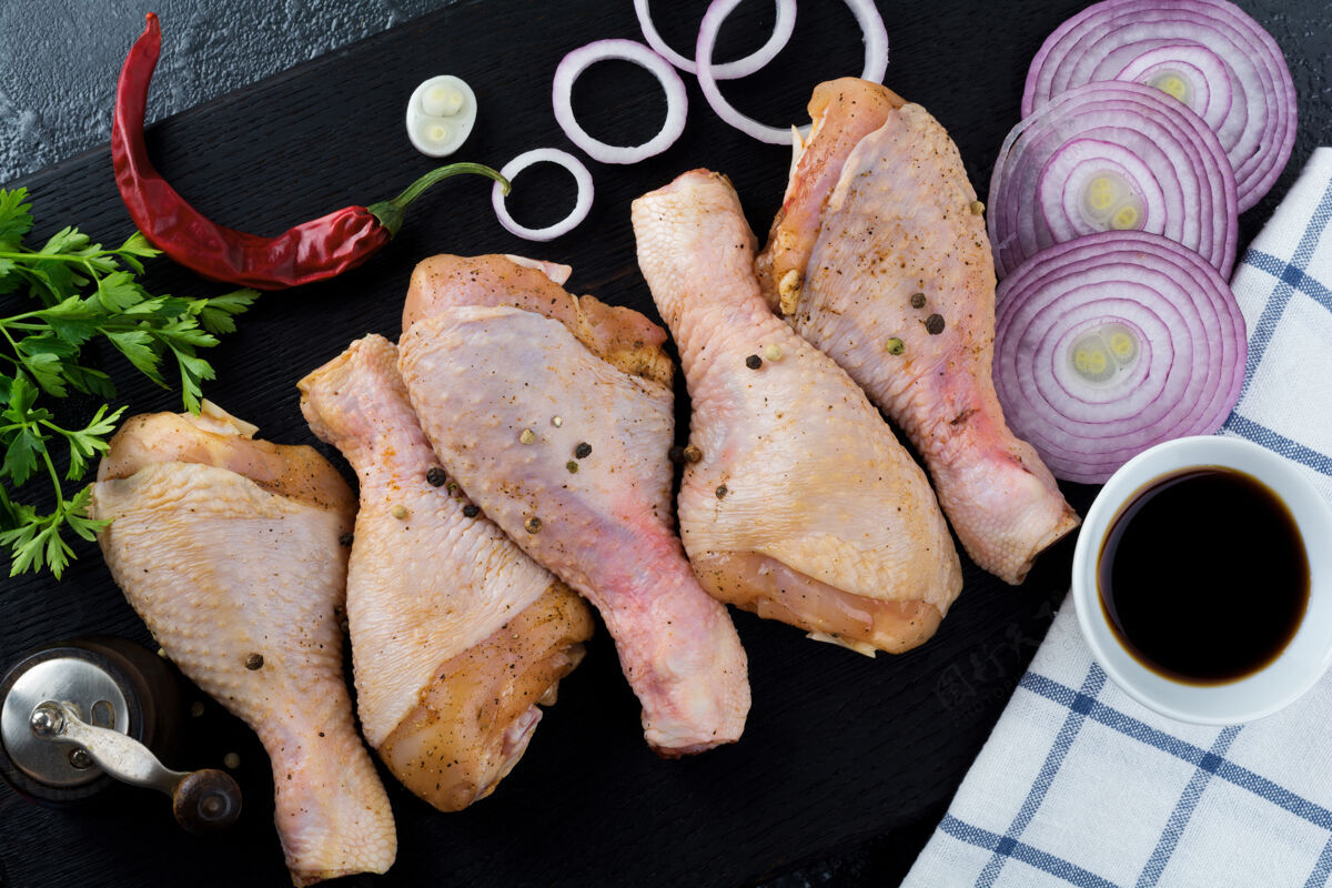 烧烤生鸡腿放在一个黑色的木架上 用胡椒粉 酱油 欧芹和洋葱腌制海洋生的鸡肉