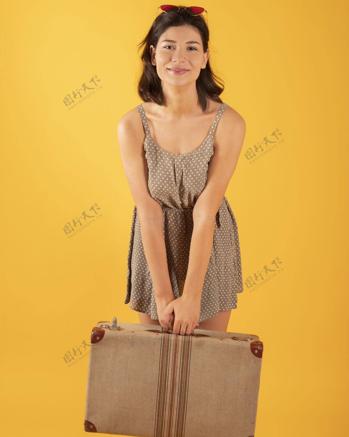 女士黄墙上挂着手提箱的女人女性女人帽子