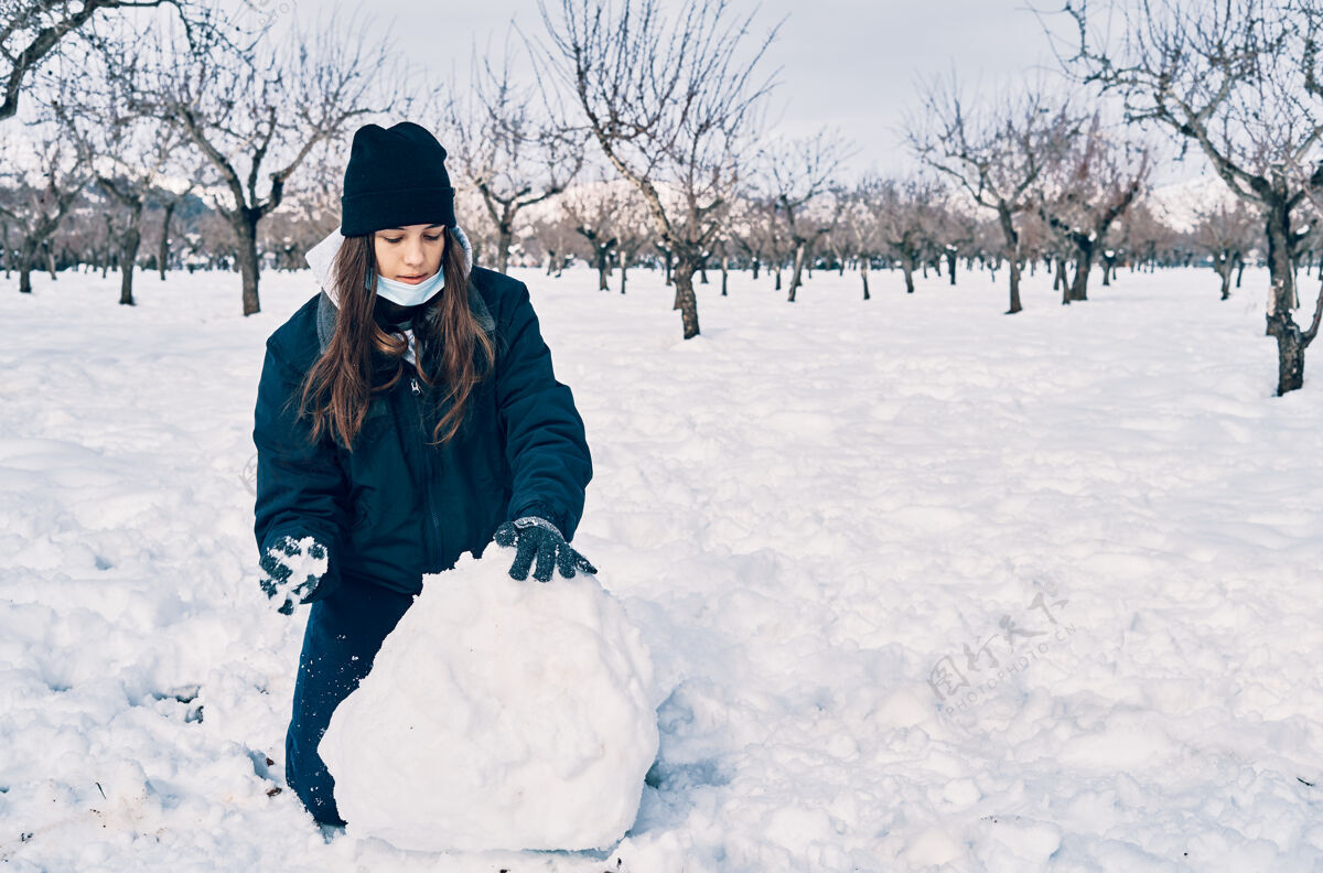 冬天一个高加索少女很暖和 戴着帽子玩雪户外快乐天气