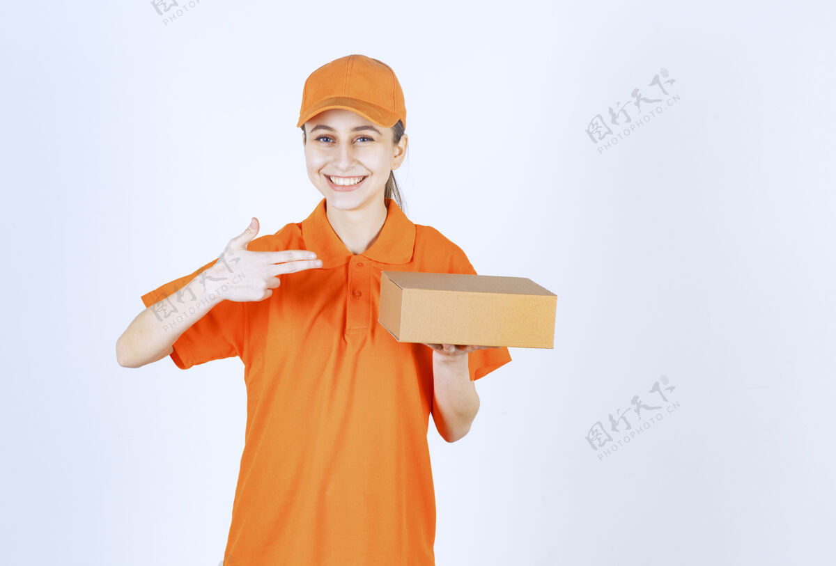 姿势穿着黄色制服的女信使手里拿着一个纸板箱聪明食品货物