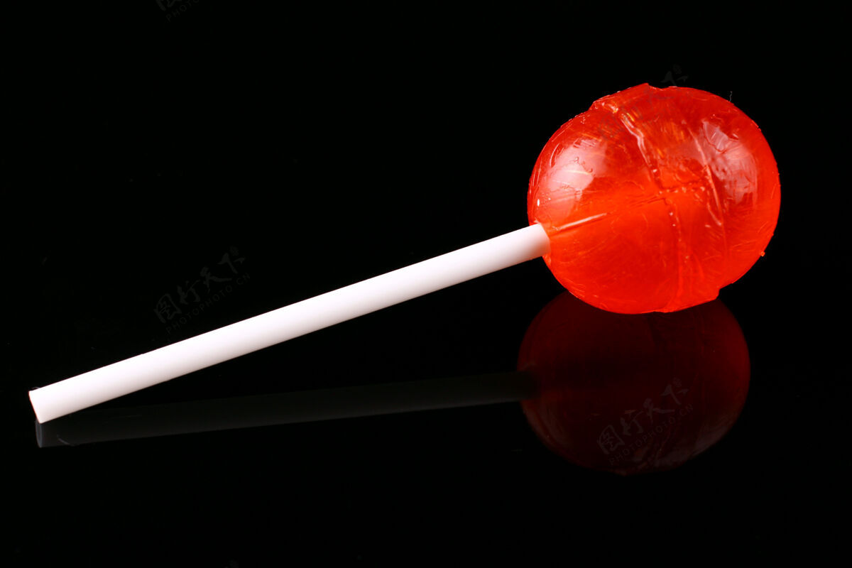 糖果黑色表面上的红色糖果对待棒喜欢
