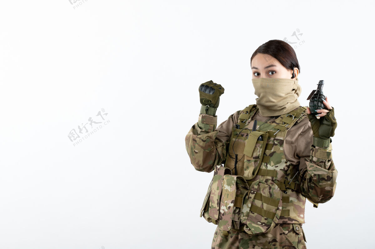视图前视图的年轻士兵伪装与手榴弹白墙军装人女