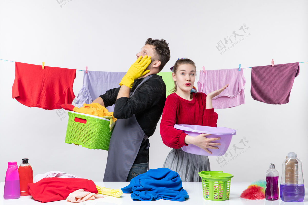 购物年轻夫妇在白墙上准备洗衣服的正面图时尚微笑商场