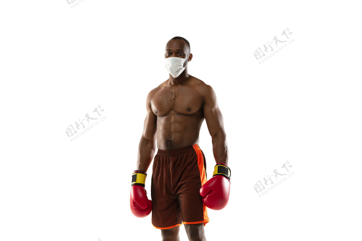 运动击退病毒戴着防护面具 手套的非裔美国拳击手面具人流行病