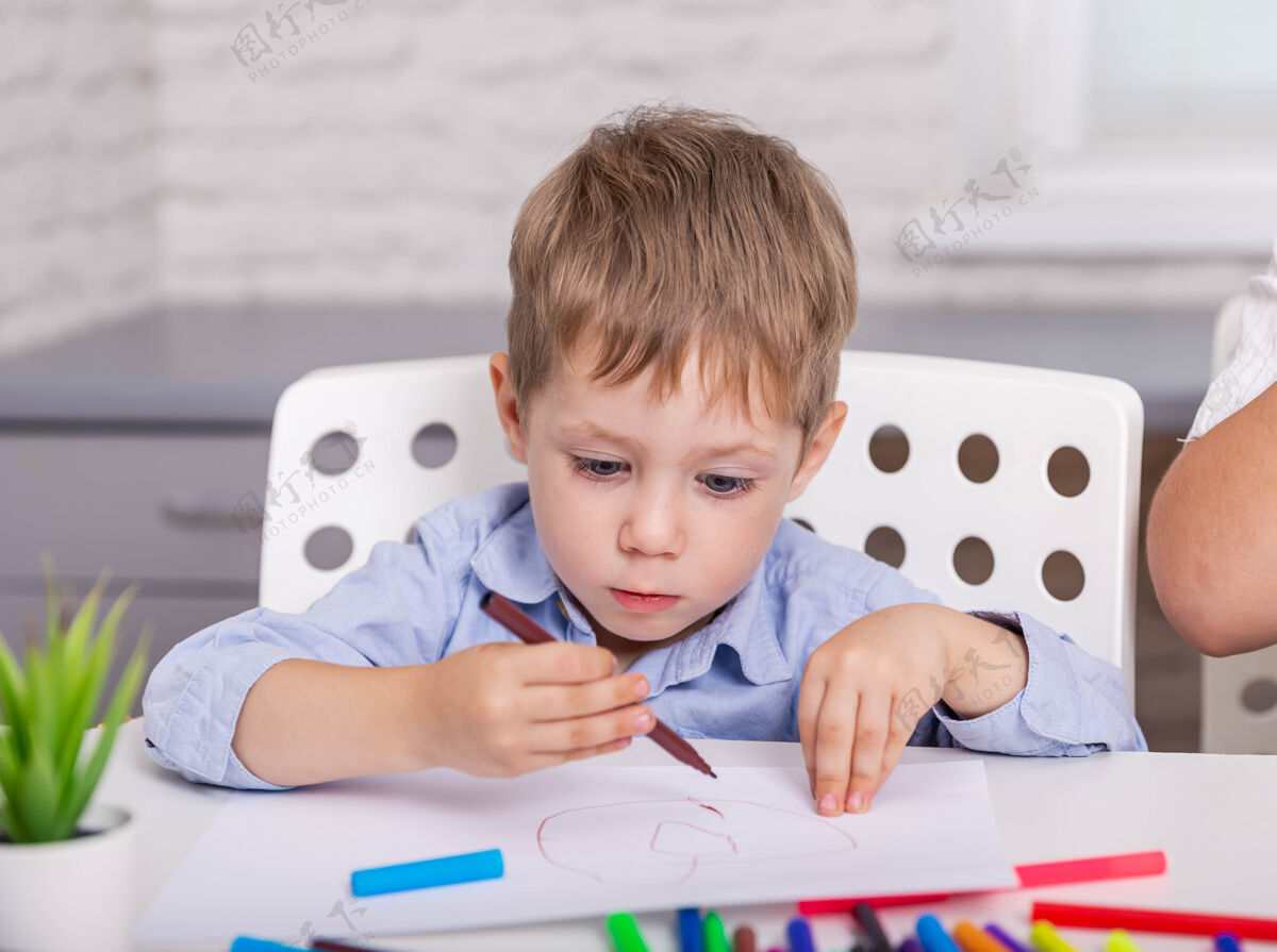 蜡笔专心的男孩在家用毛毡笔画画学习绘画绘画