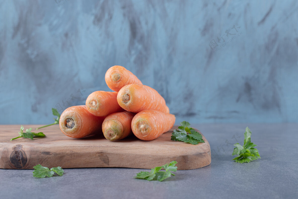 农业生胡萝卜和青菜放在砧板上 放在大理石表面新鲜绿色堆