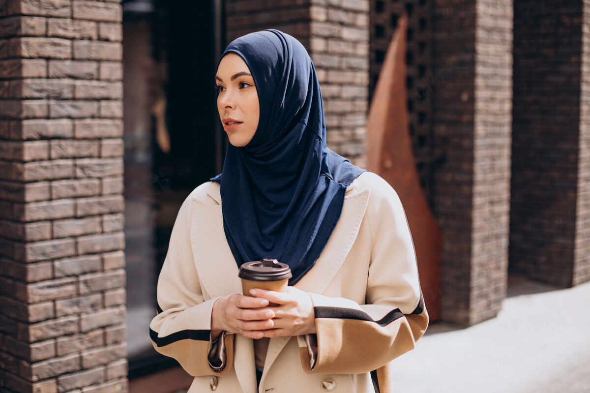穆斯林学生年轻的穆斯林妇女在喝咖啡伊斯兰漂亮自信