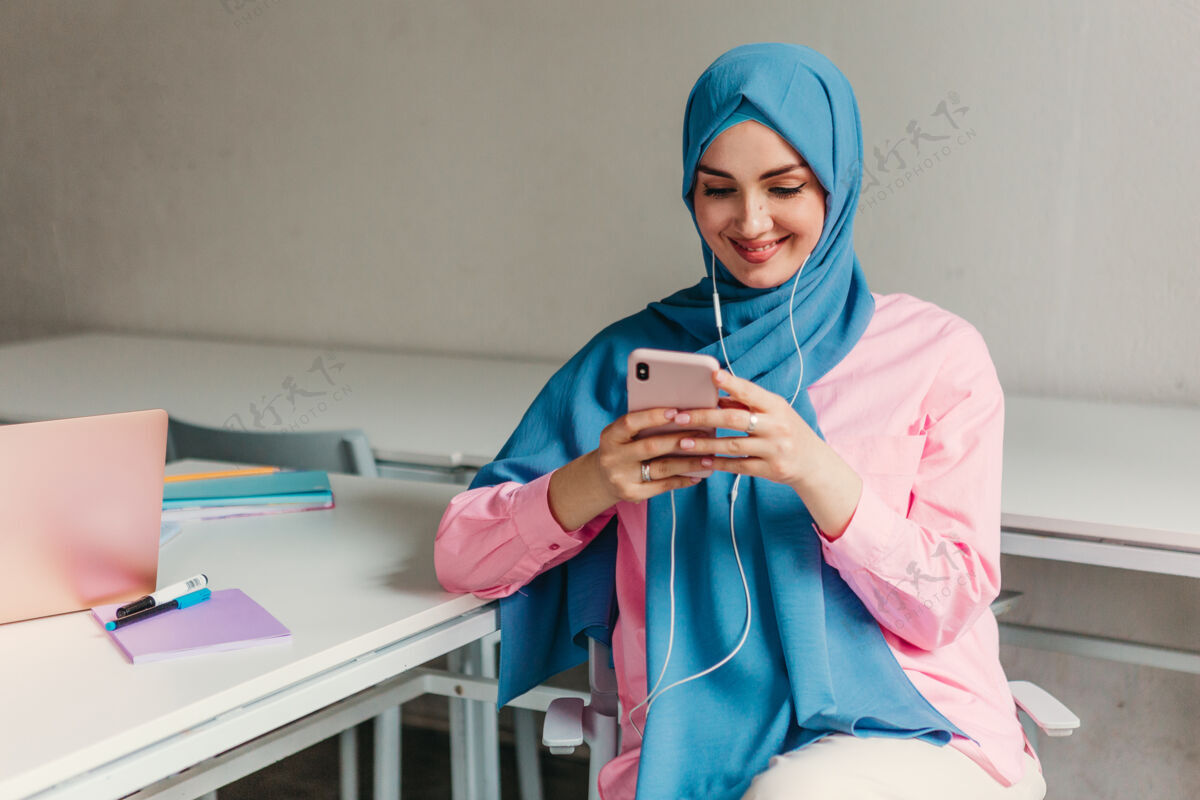 学生年轻漂亮的现代穆斯林妇女戴着头巾在办公室的笔记本电脑上工作 教育在线围巾笔记本电脑计算机