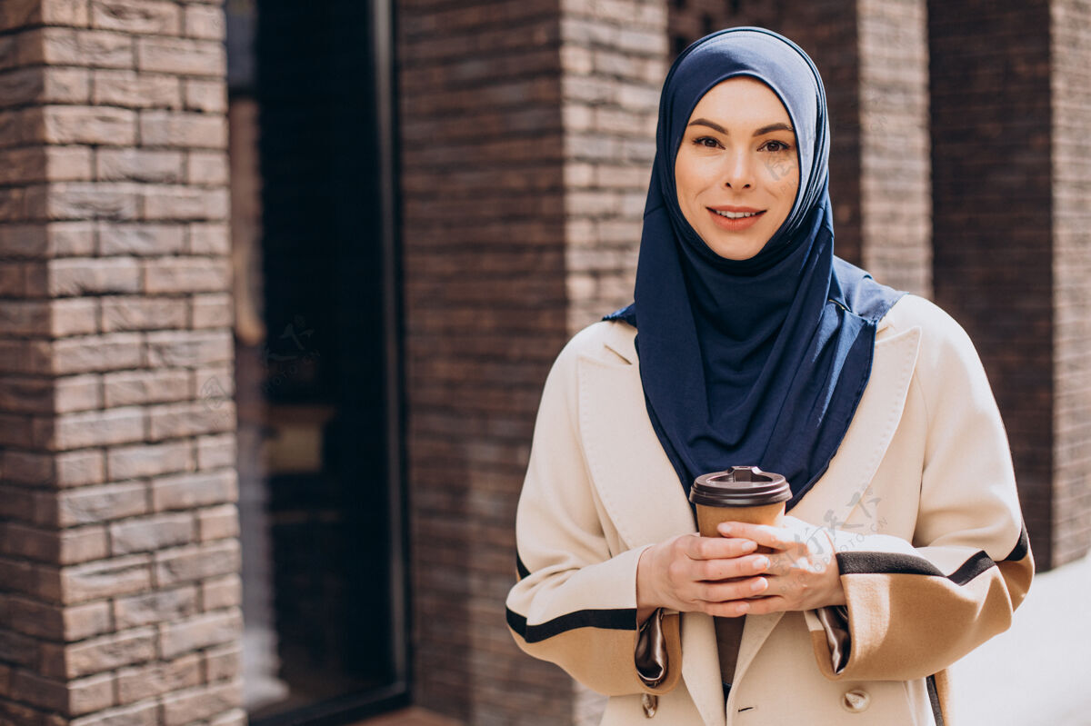 咖啡年轻的穆斯林妇女在喝咖啡自信头巾穆斯林女人