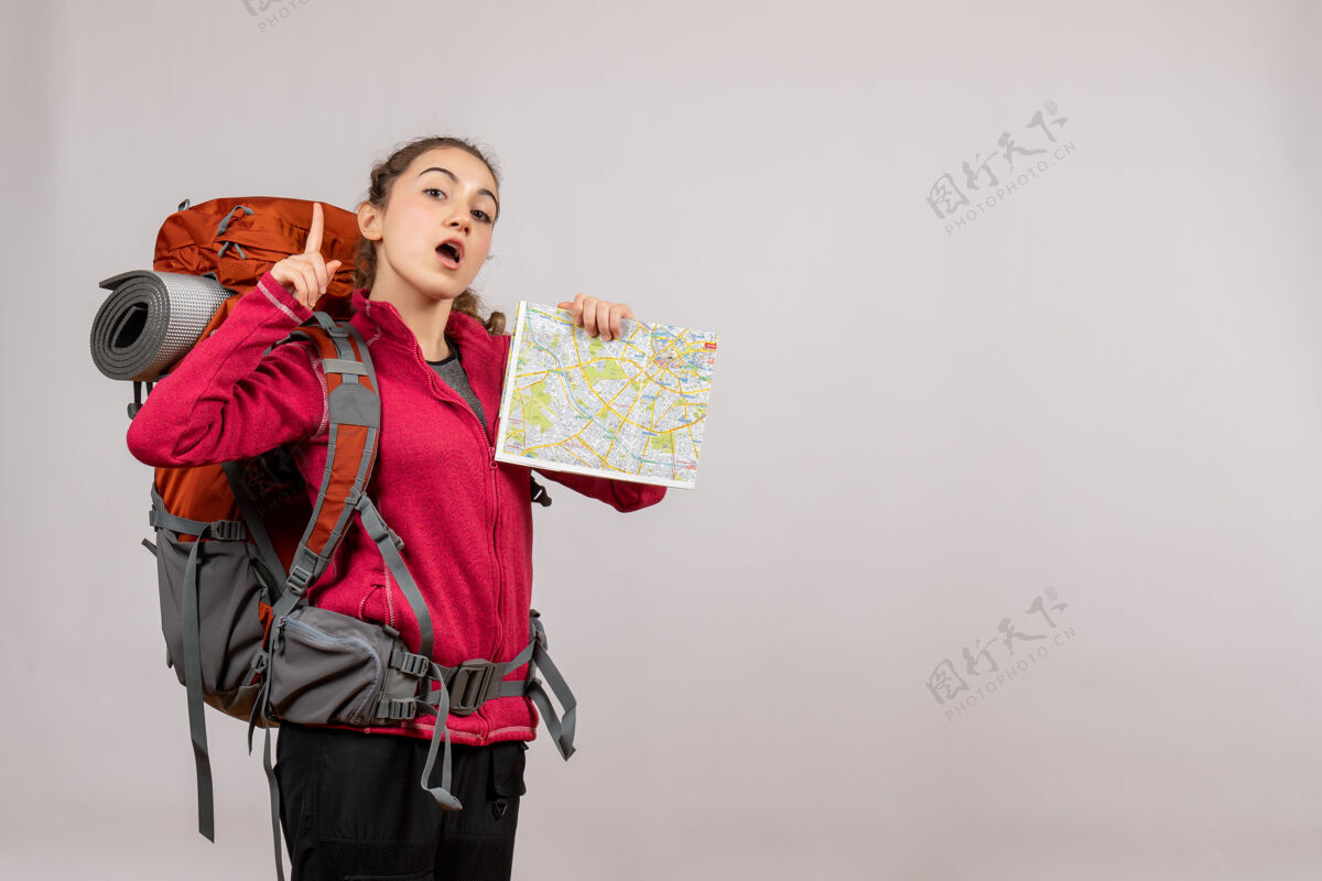 旅游正面图年轻的旅行者拿着大背包拿着地图手指向上地图年轻的旅行者背包