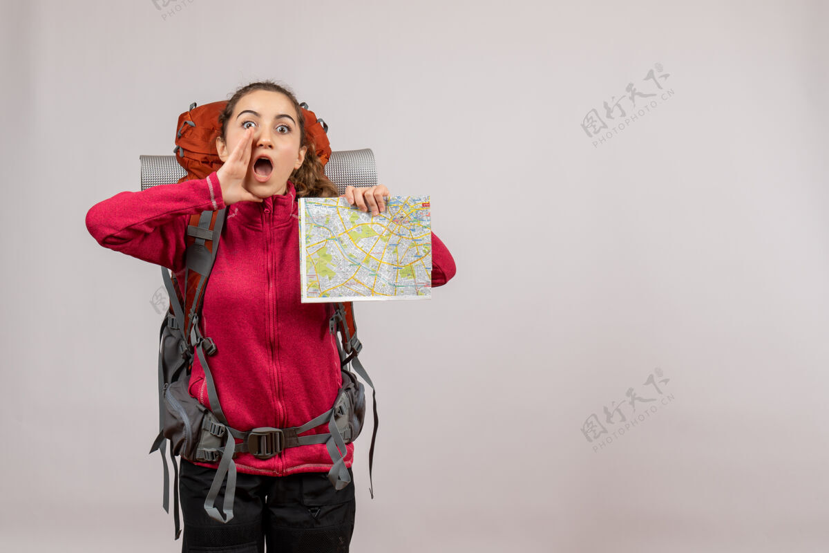 持有正面图年轻的旅行者背着大背包拿着地图叫人抄地方美丽度假复制