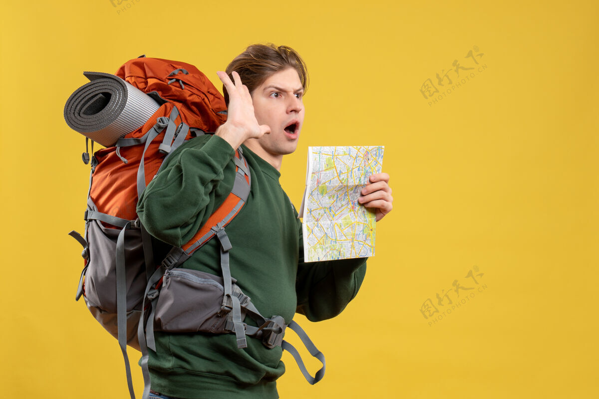 旅游正面图年轻男子背着背包拿着地图地图人年轻男性