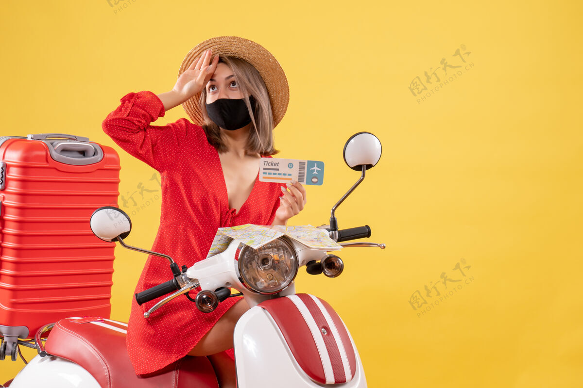 滑板车前视图：骑着轻便摩托车的年轻女士 手里拿着车票 手放在额头上人女人额头