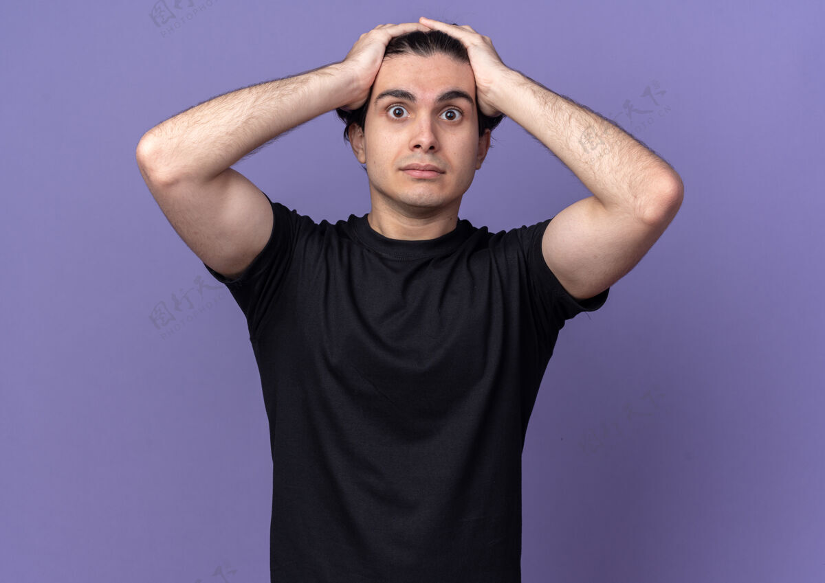 姿势一个穿着黑色t恤的年轻帅哥惊讶地把头孤立在紫色的墙上抓取男人帅哥