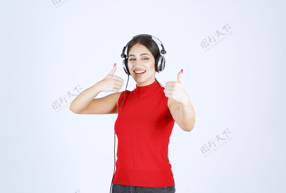 人穿着红衬衫的Dj戴着耳机欣赏音乐年轻模特舞蹈