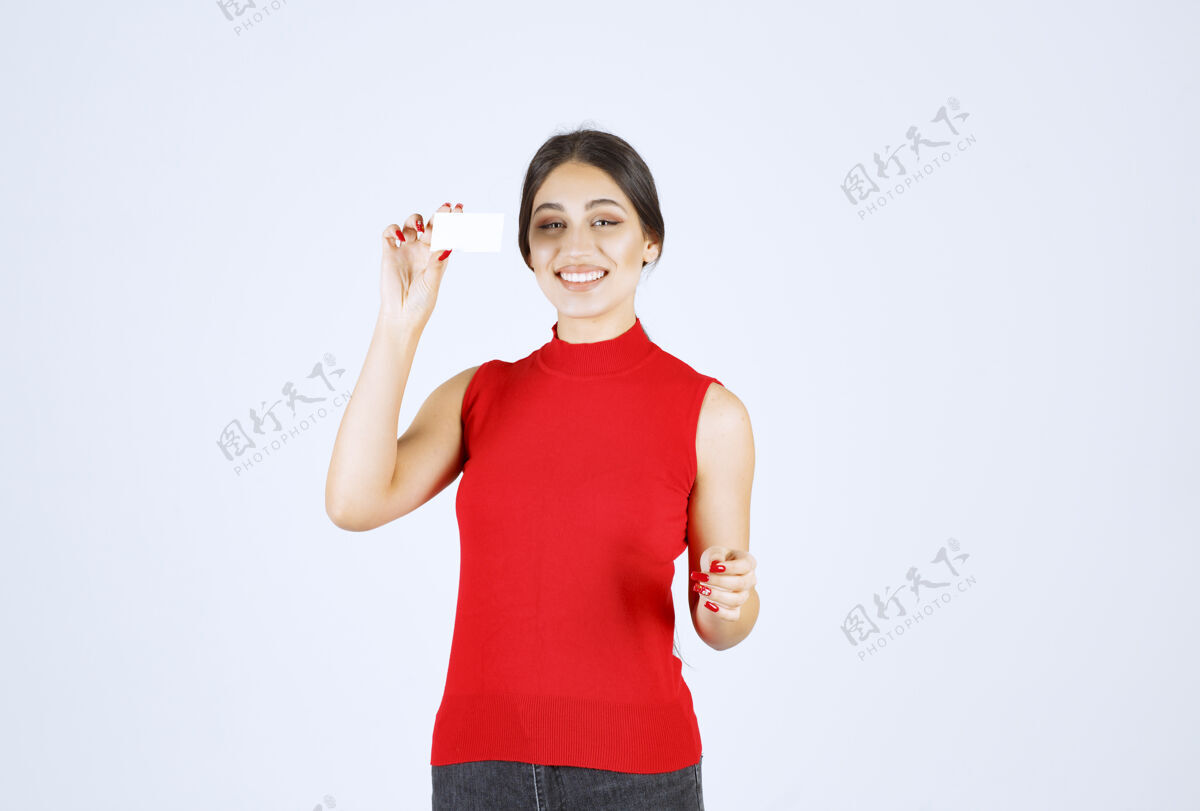 模特穿着红衬衫的女孩拿着名片 看上去很满意员工好工人