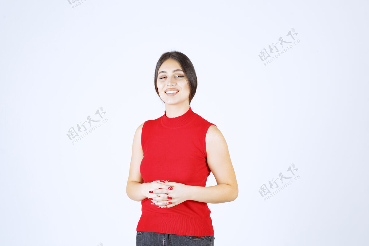 休闲穿红衬衫的女孩摆出中性 积极和吸引人的姿势女人人年轻