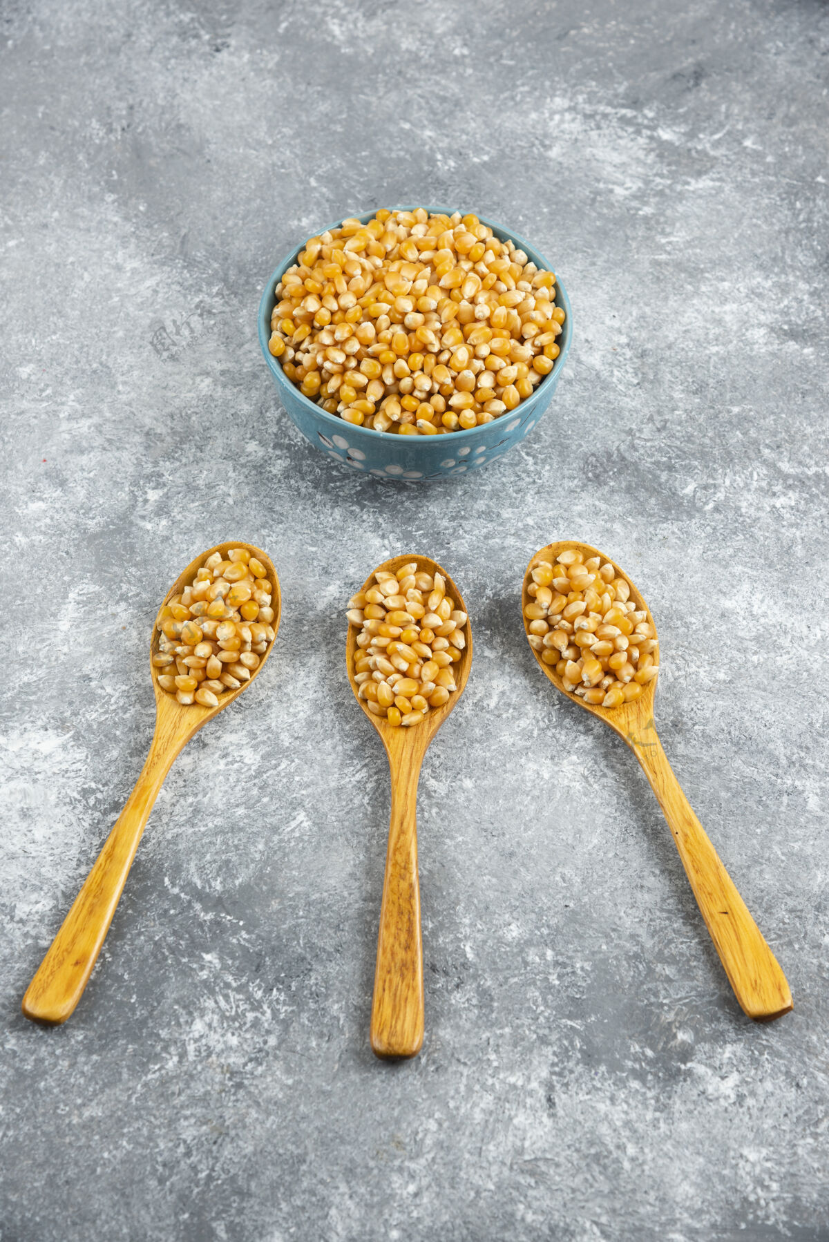 堆用汤匙和碗盛生玉米粒勺子种子有机