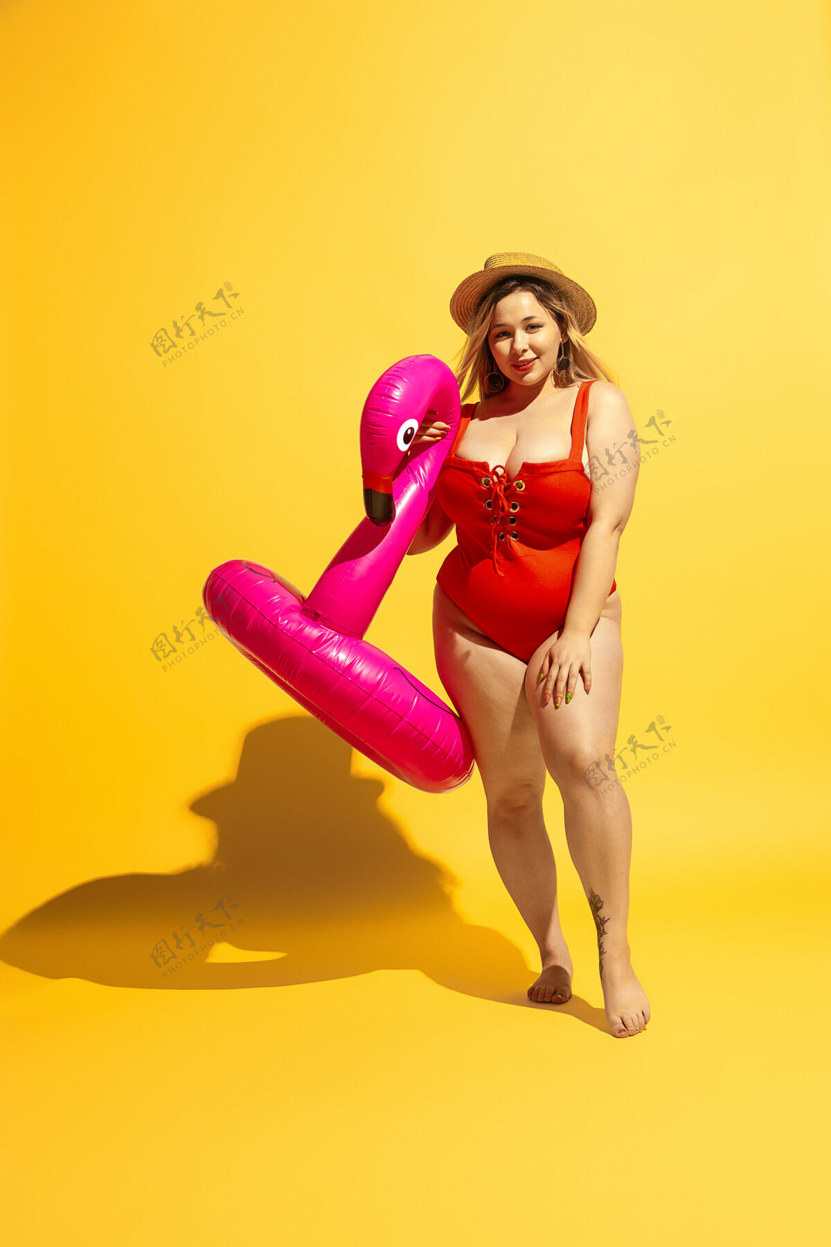 专业年轻的白人大号女模特在黄墙上准备度假穿着红色泳衣和帽子的女人在游泳游泳混合积极