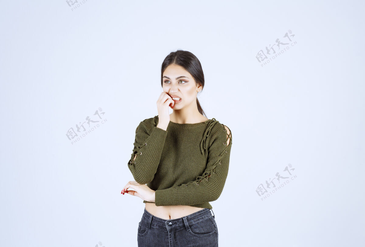 模特一位年轻漂亮的女模特站在白墙上摆姿势的画像女人站女孩