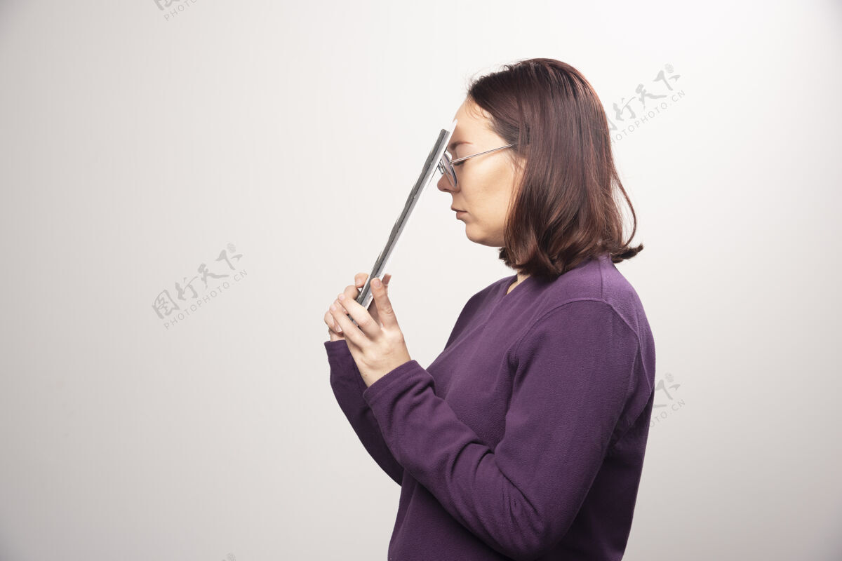 磁带一个年轻的女人在一张白色的照片上摆着一个电影院的带子高质量的照片女士镜头人类