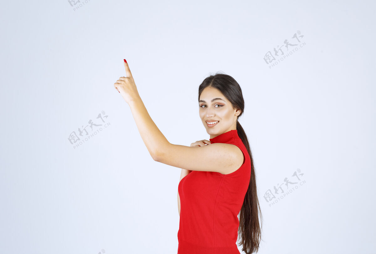 女穿红衬衫的女孩举手指着上面年轻职员工人