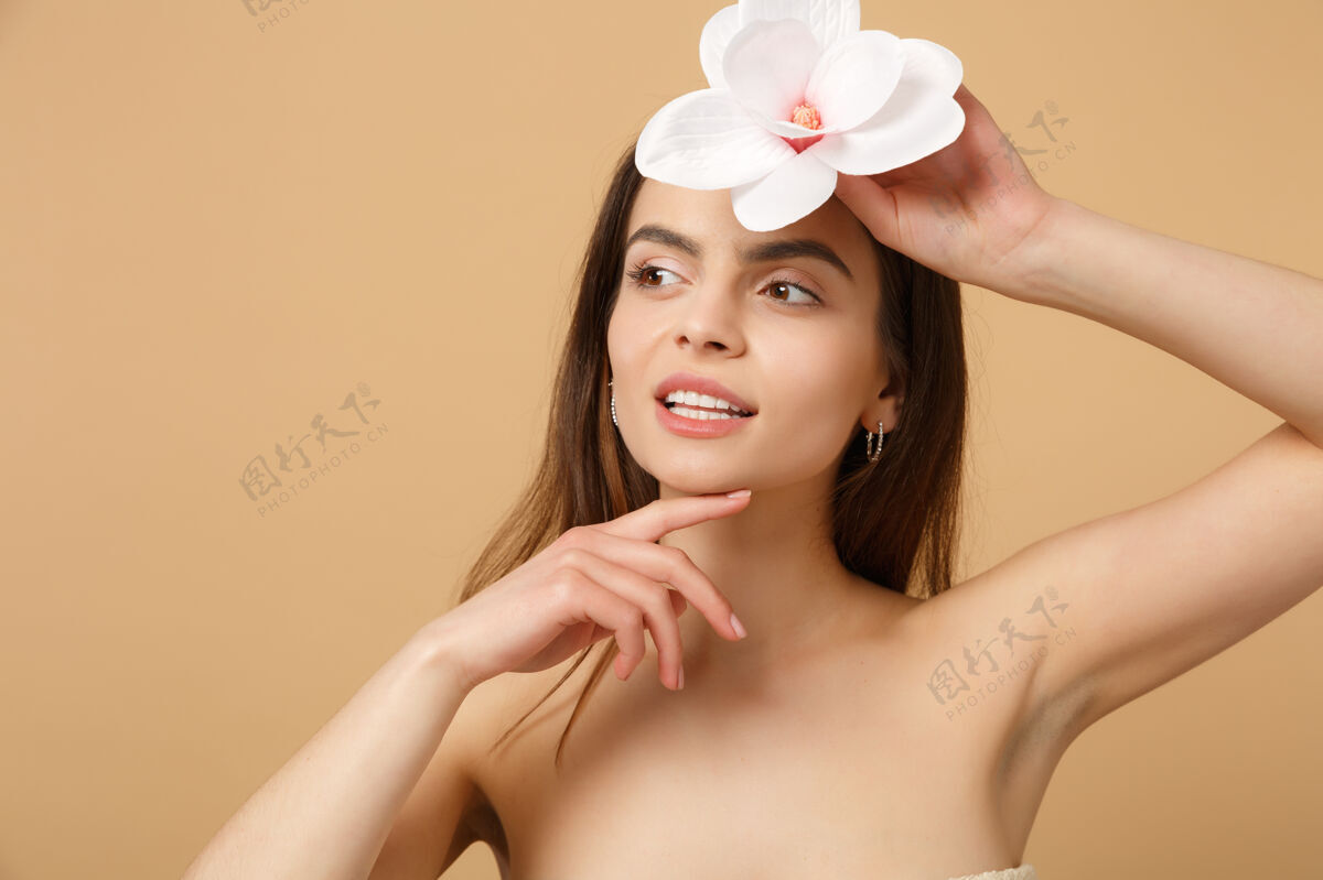胶原蛋白特写黑发半裸女人完美的皮肤 裸妆隔离在米色粉彩墙上身体柔嫩新鲜